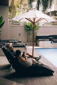 two people are laying on a raft next to a pool at Hi Cube Hostel in Canggu