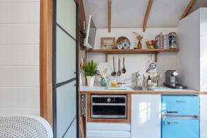 a kitchen with a refrigerator and a sink at The Cabana Luxury Award Winning Tiny Home with Hot Tub and Private Garden 2 mins Walk to Ryde Beach in Ryde