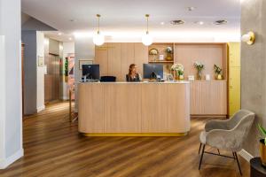 a woman sitting at a counter in an office at Petit Palace Puerta del Sol in Madrid