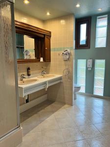 a bathroom with two sinks and a mirror and a toilet at Hôtel l'Orée des Roches in Saales +54 photos