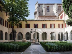 an exterior view of a building with a tower at Jules César Hotel & Spa Arles - MGallery Collection in Arles