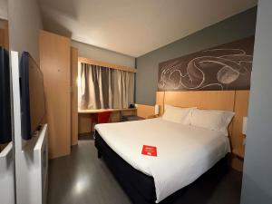 a bedroom with a large white bed and a flat screen tv at ibis Jundiai Shopping in Jundiaí +93 photos