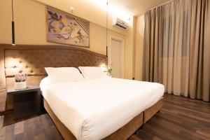 um quarto com uma grande cama branca em um quarto em Hotel Ristorante Ala d'Oro em Lugo