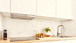 een keuken met witte kasten en een spoelbak bij Downtown La Torre in A Coruña