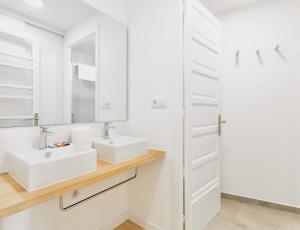 een witte badkamer met een wastafel en een spiegel bij Downtown La Torre in A Coruña +11 foto's