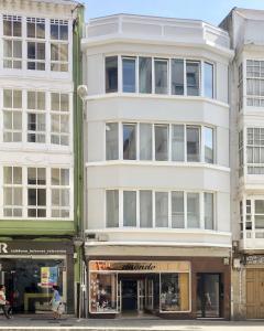 een hoog wit gebouw aan een stadsstraat bij Downtown La Torre in A Coruña