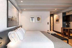 a bedroom with a white bed and a television at ART Boutique in A Coruña +7 photos
