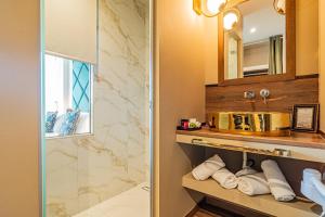 a bathroom with a sink and a shower with towels at Golden Rooms in Ioannina