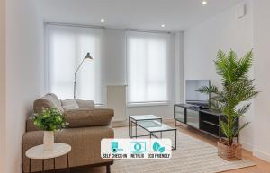 een woonkamer met een bank en een tv bij Santa Lucía in A Coruña