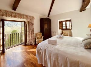 ein Schlafzimmer mit einem großen weißen Bett und einem Balkon in der Unterkunft Prioral Countryside Villa in Miño