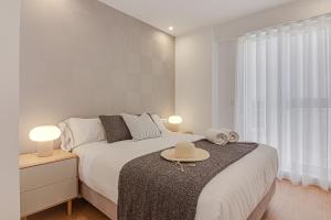 een slaapkamer met een bed en een tafel met hoeden erop bij Santa Lucía in A Coruña