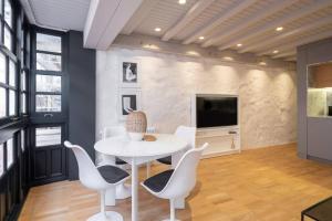 a dining room with a table and chairs and a tv at ART Boutique in A Coruña