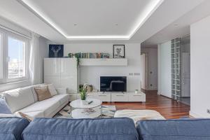 a living room with a couch and a tv at Riazor Ocean View Apartment in A Coruña