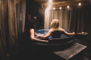 2 femmes assises dans une baignoire dans une salle de bains dans l'établissement Nasza Baza wśród drzew prywatny dom z balią - jacuzzi Miedziana Góra Kielce świętokrzyskie, à Ćmińsk
