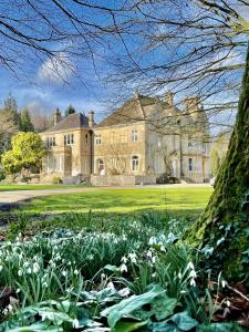 Una casa grande con flores delante de ella. en The Green, en Wingfield