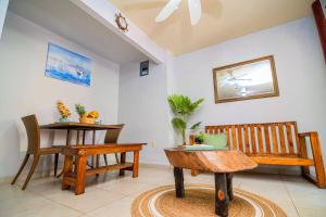 uma sala de estar com dois bancos e uma mesa em Bonsai Rentals - West Bay Private Rooms em West Bay