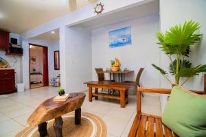 uma sala de estar com uma mesa e uma cadeira em Bonsai Rentals - West Bay Private Rooms em West Bay