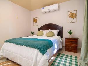 um quarto com uma cama grande com um cobertor azul em Bonsai Rentals - West Bay Private Rooms em West Bay mais 28 fotografias