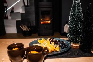 une table avec une assiette de nourriture à côté d'un sapin de Noël dans l'établissement Nasza Baza wśród drzew prywatny dom z balią - jacuzzi Miedziana Góra Kielce świętokrzyskie, à Ćmińsk