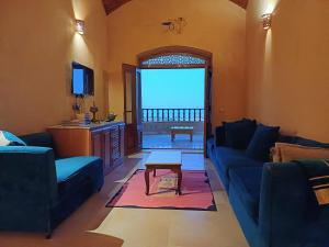a living room with a blue couch and a table at Iteru inn villa in Fayoum