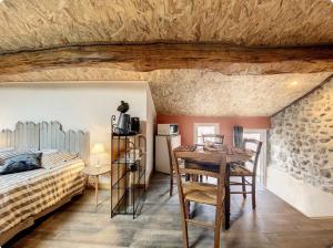 a bedroom with a bed and a table in a room at Chambre d'hôtes familiale Marina in Sampzon