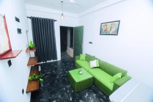 a living room with a green couch and a table at Villa Vows in Tangalle