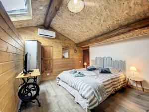 a bedroom with a bed and a television in it at Chambre d'hôtes familiale Marina in Sampzon