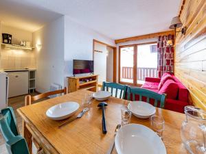 a dining room with a wooden table with plates on it at Appartement cosy 6 pers au pied des pistes - FR-1-807-1 in Saint-François-Longchamp