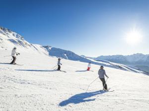 a group of people skiing down a snow covered slope at Appartement lumineux 36m² aux pieds des pistes, 6 pers, Saint-François-Longchamp - FR-1-807-19 in Saint-François-Longchamp +6 photos