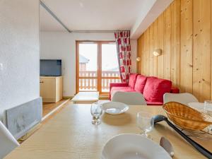 a living room with a table and a red couch at Appartement 6 pers aux pieds des pistes à Saint-François-Longchamp - FR-1-807-29 in Saint-François-Longchamp