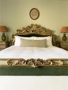 Un dormitorio con una cama dorada con una colcha blanca. en The Green, en Wingfield