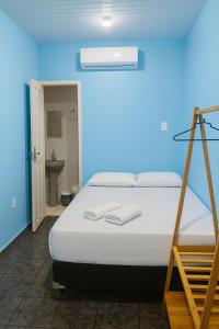 a bedroom with a bed with a blue wall at Alvorada Suite in Manaus