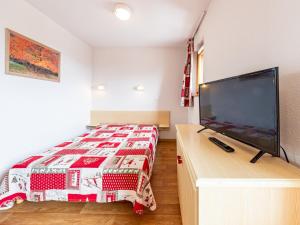 a bedroom with a bed and a flat screen tv at Appartement 6 pers, pieds des pistes, St-François-Longchamp - FR-1-807-105 in Saint-François-Longchamp