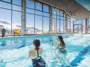 two women in a swimming pool with mountains in the background at Appartement 6 pers, 2 ch, proche pistes et commerces - FR-1-807-123 in Saint-François-Longchamp