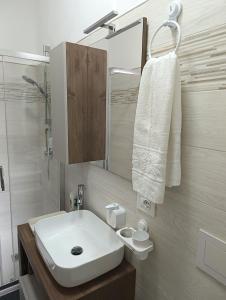 ein Badezimmer mit einem weißen Waschbecken und einer Dusche in der Unterkunft Siderno Beach Stay - Guest House in Siderno Marina