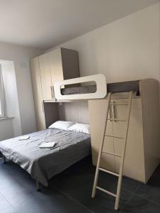 ein kleines Schlafzimmer mit einem Etagenbett und einer Leiter in der Unterkunft Siderno Beach Stay - Guest House in Siderno Marina