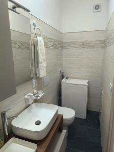 ein Badezimmer mit einem weißen Waschbecken und einer Toilette in der Unterkunft Siderno Beach Stay - Guest House in Siderno Marina + 6 Fotos