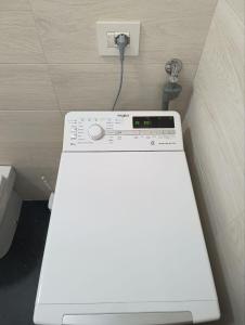 eine Waschmaschine mit einem an eine Steckdose angeschlossenen Kabel in der Unterkunft Siderno Beach Stay - Guest House in Siderno Marina