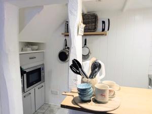 eine Küche mit einer Theke mit Tassen und Küchenutensilien in der Unterkunft Normanby Cottage Runswick Bay in Runswick