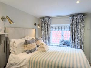 Schlafzimmer mit einem Bett und einem Fenster in der Unterkunft Normanby Cottage Runswick Bay in Runswick