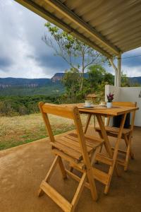 un tavolo in legno e una sedia sul portico con vista di Janela da Canastra a Capitólio