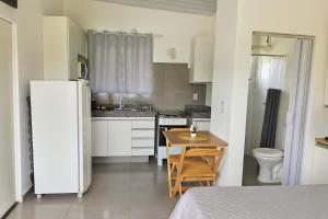 a small kitchen with a table and a refrigerator at Janela da Canastra in Capitólio +6 photos