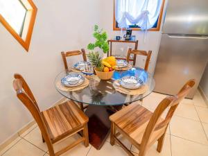 ウェスト・ベイにあるBonsai rentals - West Bay Private Roomsのフルーツのボウルと冷蔵庫が置かれたダイニングテーブル