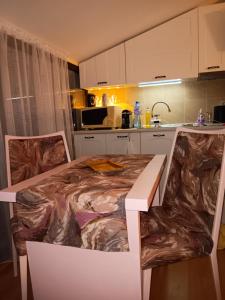a kitchen with a table and chairs in a kitchen at Аppartment Dreams in Pamporovo