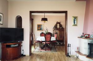 ein Esszimmer mit Tisch und Stühlen und einem Fernseher in der Unterkunft Kaschubische Schweiz : Oase der Entspannung in Łyśniewo