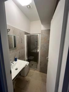 un bagno bianco con doccia e lavandino di Villa Miglietta a Torre Lapillo