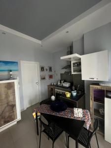 una cucina con un tavolo e sedie in una stanza di Villa Miglietta a Torre Lapillo