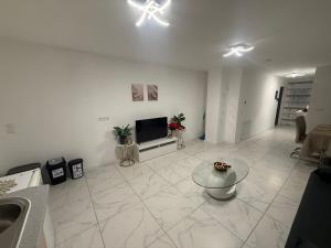 a white living room with a television and a table at Apartment-Alex in Vienna