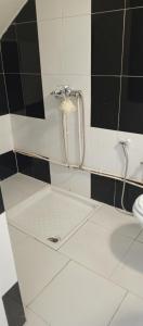 a bathroom with a shower in a black and white tiled wall at Chambre single in Tunis +3 photos