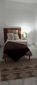 a bedroom with a large bed with a table at Chambre single in Tunis